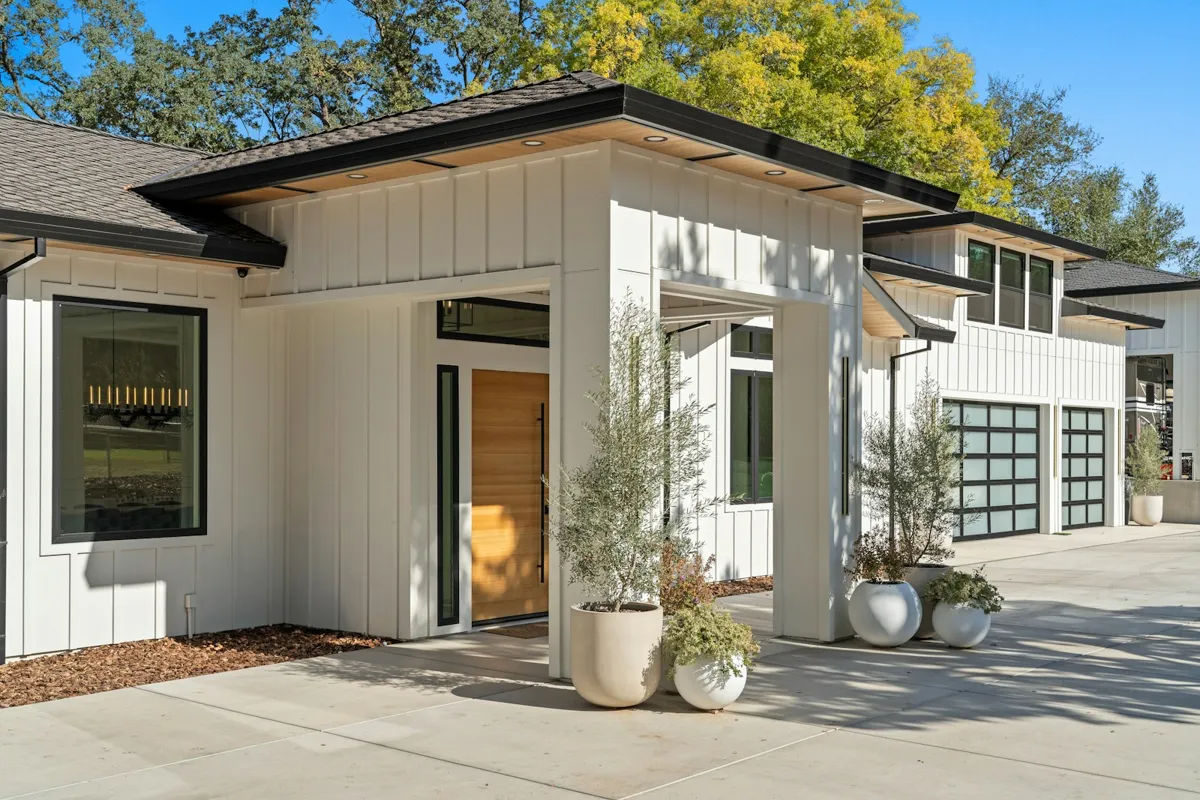 Modern home with full-view glass garage doors beside the entry
